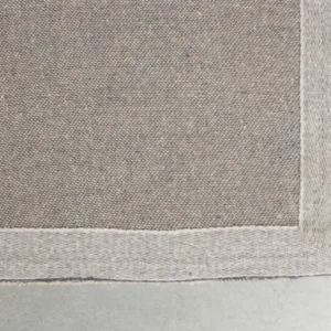 Detailansicht der beigefarbenen Webkante und Nähte des handgefertigten Teppich Doodle 160x230 Beige.