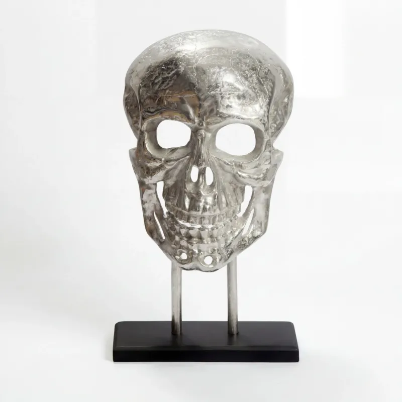 Standdeko Totenkopf Aluminium Silber 57 cm mit schwarzem Gestell in Vorderansicht auf schwarzem Sockel.